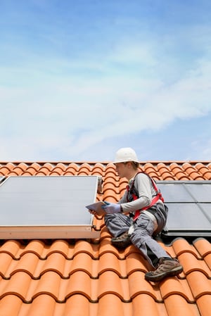 Man on roof solar energy installation