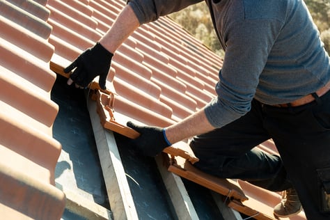 Worker installs roof tiles in Las Vegas on roof of home